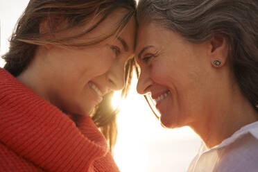 Loving mother and daughter touching foreheads to each other - AAZF01268