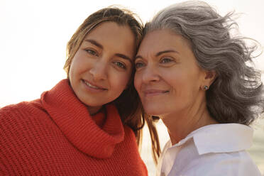 Smiling mother and daughter in front of sky - AAZF01271