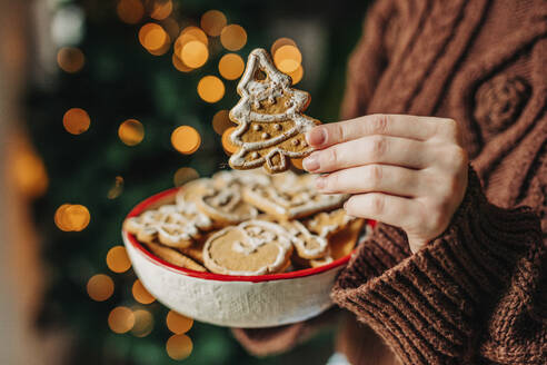 Woman holding gingerbread cookies at home - VSNF01478