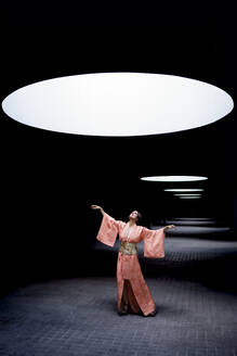 Frau in Kimono und mit Blick auf Scheinwerferlicht - JSMF02931