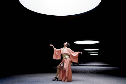 Frau in Kimono und mit Blick auf Scheinwerferlicht - JSMF02934