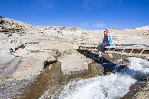 Tourist auf dem Steg über den Bach im Nationalpark Hohe Tauern, Österreich - FOF13707