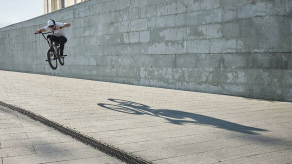 Mann macht Stunt mit BMX-Rad vor einer Wand - MRPF00037