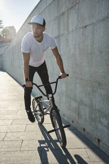 Mann fährt BMX-Rad in der Nähe einer Betonwand - MRPF00038