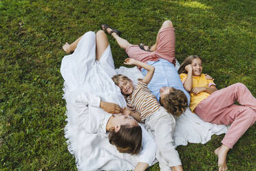 Familie genießt zusammen liegend im Park - NDEF01398