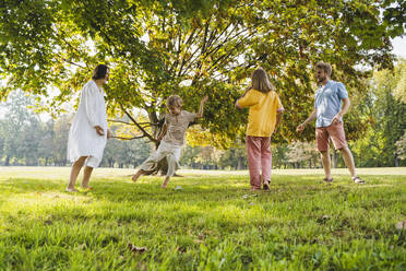 Glückliche Familie genießt Wochenende spielen auf dem Rasen im Park - NDEF01421