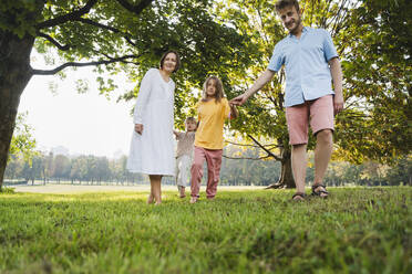 Vater und Mutter spielen mit Kindern im Park - NDEF01429