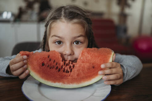 Mädchen isst ein Stück Wassermelone zu Hause - ANAF02421