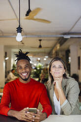 Lächelnde multirassische Geschäftskollegen in einem Café - JOSEF22097