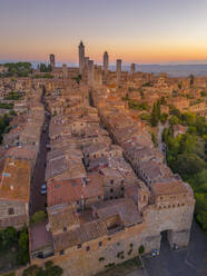 Elevated view of rooftops and town at sunrise, San Gimignano, Tuscany, Italy, Europe - RHPLF28938