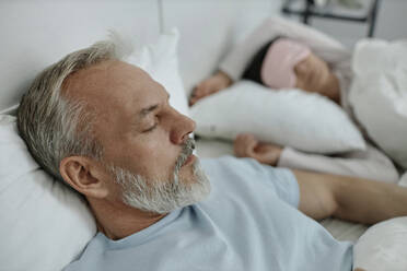 Grauer Mann schläft neben seiner Frau im Bett am Morgen - KPEF00337