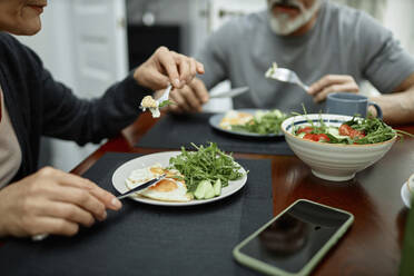 Couple eating fried eggs and salad for breakfast at home - KPEF00371