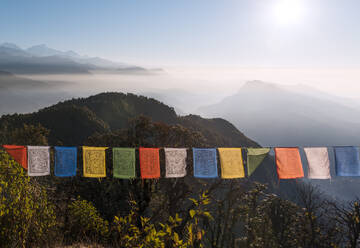 Bunte Gebetsfahnen vor einer weiten Berglandschaft am Fuße des Annapurna Circuit im Himalaya, Australian Camp, Nepal, Asien - RHPLF29455