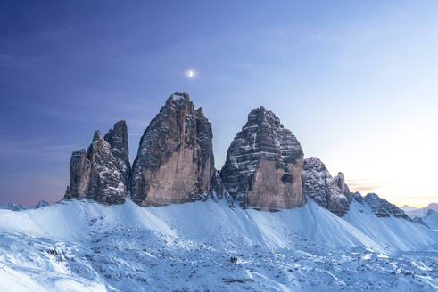 Moon above Tre Cime di Lavaredo at dusk, winter time, Tre Cime di Lavaredo (Lavaredo peaks) (Drei Zinnen), Sesto (Sexten), Dolomites, South Tyrol, Italy, Europe - RHPLF29858