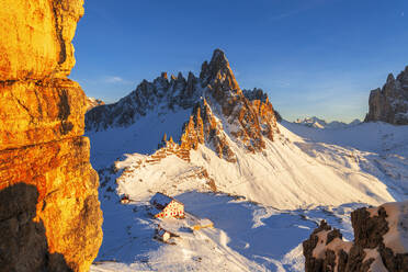 Winter sunset on Paterno mountain and Locatelli hut covered with snow, Tre Cime di Lavaredo (Lavaredo peaks), Sesto (Sexten), Dolomites, South Tyrol, Italy, Europe - RHPLF29862