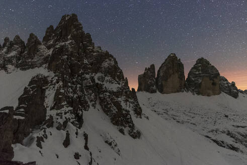 Starry night over Tre Cime di Lavaredo (Lavaredo peaks) and Paterno mountain, winter view, Sesto (Sexten), Dolomites, South Tyrol, Italy, Europe - RHPLF29865