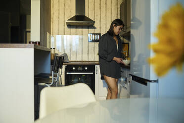 Young woman preparing breakfast in kitchen at home - DSHF01129
