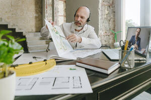 Architekt bespricht Entwurf mit Kollege per Videoanruf über Laptop am Schreibtisch - YTF01434