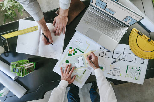 Architects working on blueprints at desk - YTF01438