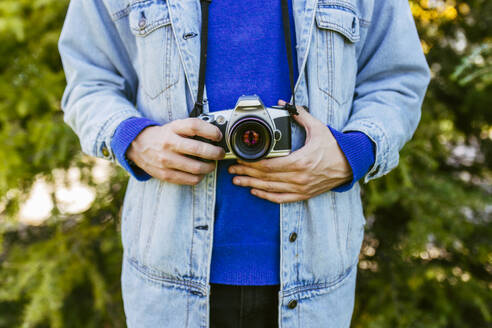 Mann mit Jeansjacke und Kamera in der Hand - EGHF00807