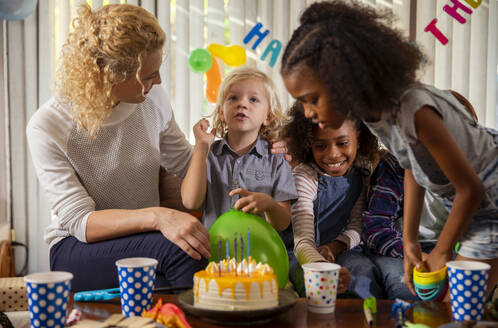 Family and friends celebrating birthday at home - IKF01428