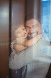 Happy father hugging son at home - ANAF02468