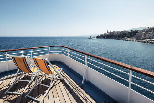 France, Haute-Corse, Deck chairs on bow of ferry sailing toward coast of Corsica island - WFF00743