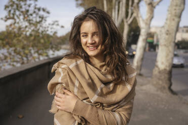 Lächelnde schöne Frau mit Schal und auf dem Fußweg stehend - YBF00315