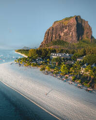 Aerial view of a woman on the beach in front of a luxury resort near Le Morne mountain, Riviere Noire, Mauritius. - AAEF24628