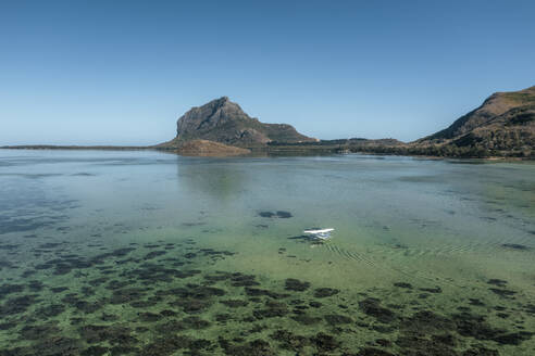 Luftaufnahme eines Wasserflugzeugs, das in einer Lagune mit Barriereriff landet, mit dem Berg Le Morne im Hintergrund, Le Morne Brabant, Riviere Noire, Mauritius. - AAEF24649