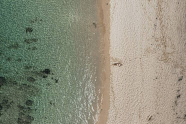 Luftaufnahme einer Frau, die sich am öffentlichen Strand von Pomponette entlang der Küstenlinie entspannt, Chemin Grenier, Bezirk Savanne, Mauritius. - AAEF24652