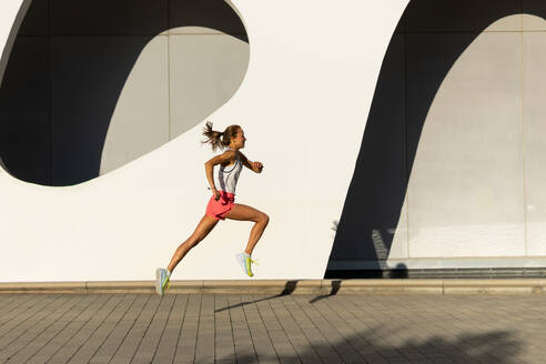 Photo of a woman is running on a brick road the Urban Landscape - ADSF49573