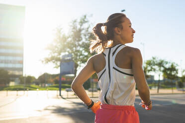 Back view photo of a woman running down a sidewalk in a city. Active Lifestyle in the Urban Jungle - ADSF49576