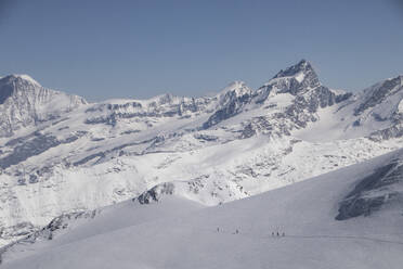 Picturesque view of mountain range with rocks covered in snow under cloudy sky at Swiss Alps - ADSF49645