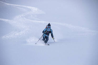 Anonymous person descending while skiing on snow covered mountain slope during vacation at Swiss Alps - ADSF49649