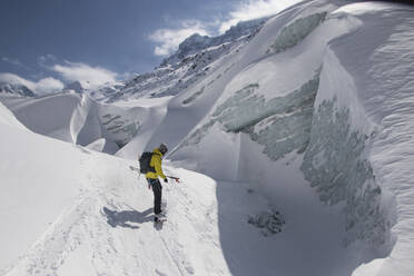 Side view of anonymous person hiking on snow covered mountain during vacation at Swiss Alps - ADSF49652