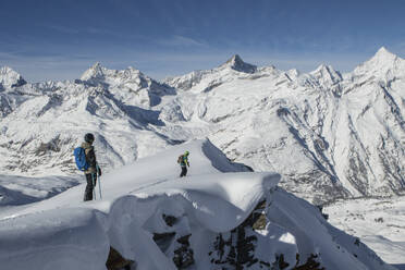 From above of side view of anonymous persons hiking on snow covered mountain during vacation at Swiss Alps - ADSF49655