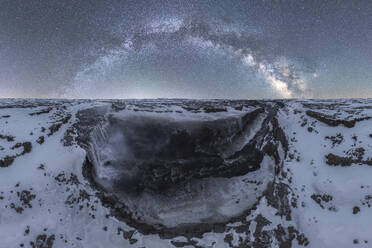Majestätischer Blick auf einen gefrorenen Wasserfall, umgeben von eisigen Klippen unter einem sternenübersäten Dämmerungshimmel, der die Gelassenheit einer Winternacht in Island einfängt - ADSF49683