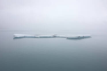 View of ice formation surrounded with calm and scenic sea water against sky in winter at Iceland - ADSF49705