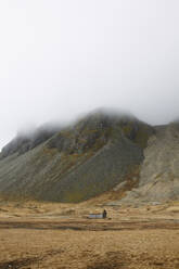 Scenic view of landscape with mountain range in background against sky in hazy weather at Iceland - ADSF49706