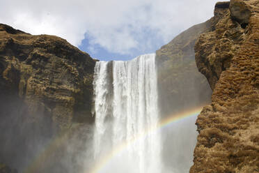 Breathtaking view of colorful rainbow over powerful waterfall on sunny day in in highlands of Iceland - ADSF49714