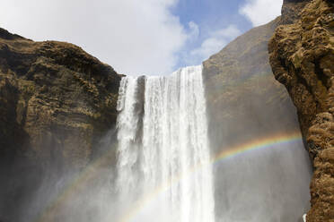 Breathtaking view of colorful rainbow over powerful waterfall on sunny day in in highlands of Iceland - ADSF49715