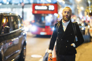 Mature man with hand in pocket standing roadside in city - WPEF07888