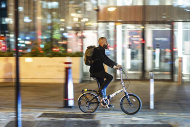 Mann pendelt mit dem Fahrrad auf der Straße in der Stadt - WPEF07891