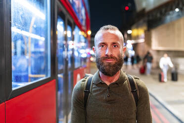 Älterer Mann mit Bart steht neben dem Bus in der Stadt bei Nacht - WPEF07919