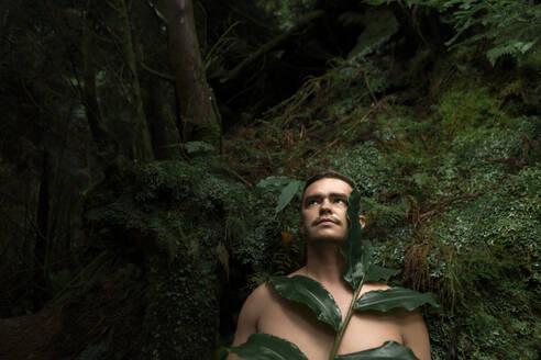 Kontemplativer Mann mit Blättern im Regenwald - WVF02060