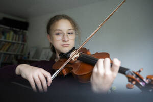 Mädchen mit Brille und Geigenspiel zu Hause - NJAF00691