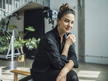 Smiling businesswoman sitting in apartment - MFF09475