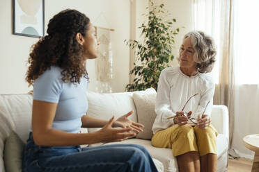Der Patient gestikuliert und spricht mit dem Therapeuten zu Hause - EBSF04076
