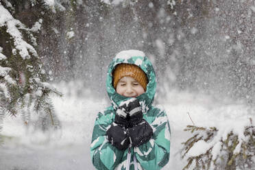 Boy with eyes closed enjoying snowfall at park - ONAF00693